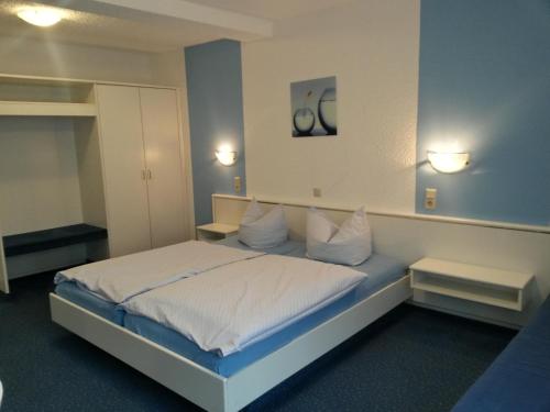 a bedroom with a bed with white sheets and pillows at Hotel Holländischer Hof in Lich