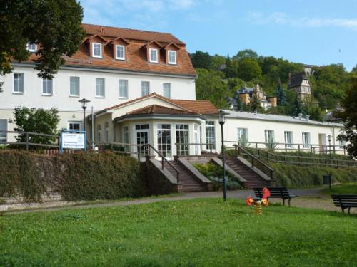 a woman and a dog in front of a large building at Ferienwohnung am Kurpark in Bad Frankenhausen