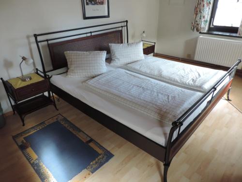 a bed with white sheets and pillows in a bedroom at Gasthof zum Richter in Mühldorf