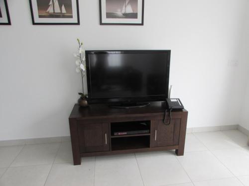 a flat screen tv sitting on top of a wooden entertainment center at BCV Private 2 Bed Penthouse Apartment With Pool View Dunas Resort 1145 in Santa Maria
