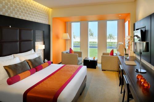 a bedroom with a large bed and a living room at Hues Boutique Hotel in Dubai