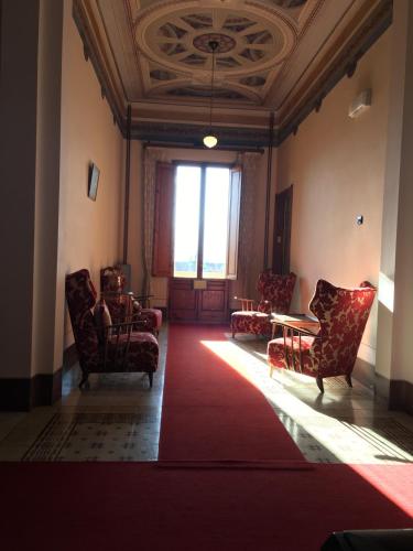 a room with chairs and a table and a red rug at Villa Moorings in Barga
