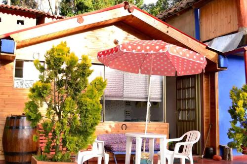 a table and chairs with an umbrella on a patio at Cabañas Yukatan Lago de Tota in Tota
