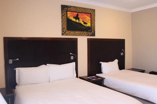 سرير أو أسرّة في غرفة في Blue Mountain Inn Lesotho