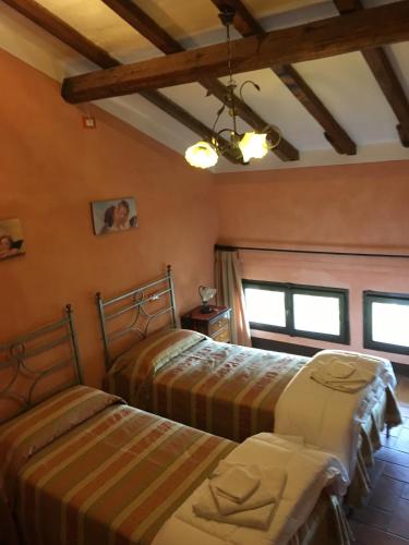 two beds in a room with orange walls at Villa Moorings in Barga