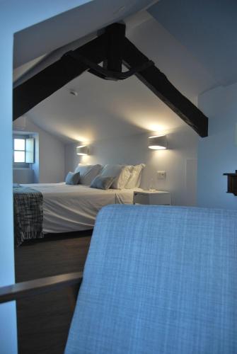 a bedroom with a large bed and a window at Guest House Santa Clara in Coimbra