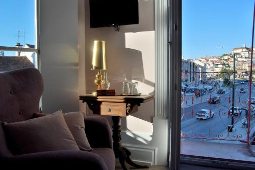 a living room with a window with a view of a city at Guest House Santa Clara in Coimbra