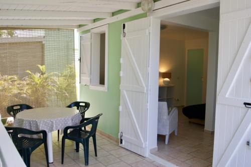 una puerta que da a un comedor con mesa y sillas en Résidence Anamanga, en Sainte-Anne
