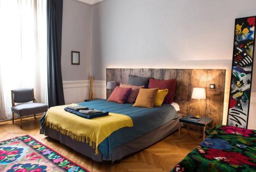 een slaapkamer met een groot bed met kleurrijke kussens bij Augusta in Cluj-Napoca