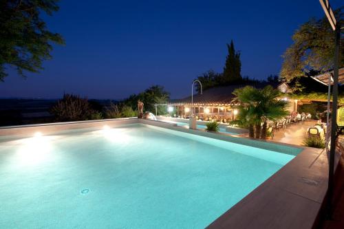 a swimming pool at night with a house at Hotel Il Pietreto in Colle Val D'Elsa