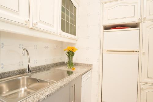 卡列羅港的住宿－VistAgua，白色的厨房配有水槽和冰箱