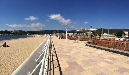 a walkway on a beach with aceanpectpectpectensionalensionalensionalensional at Departamento Torres del Mar de Dichato in Dichato