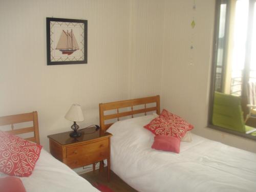 1 dormitorio con 2 camas y mesa con lámpara en Departamento Torres del Mar de Dichato, en Dichato