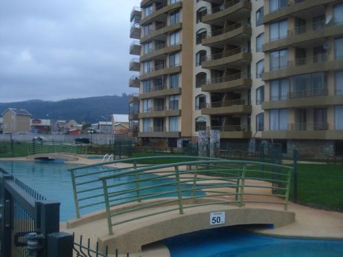 a swimming pool in front of a large apartment building at Departamento Torres del Mar de Dichato in Dichato