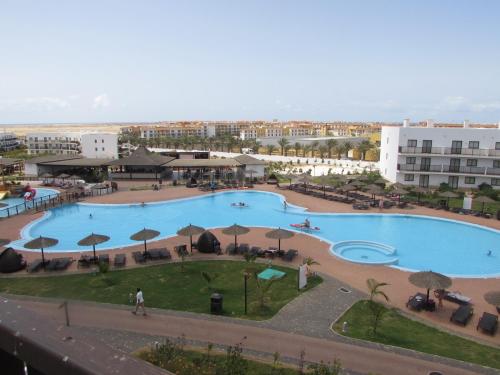 an overhead view of a large swimming pool with umbrellas at BCV Private 1 Bed Apartment Ground Floor Dunas Resort 6067 in Santa Maria