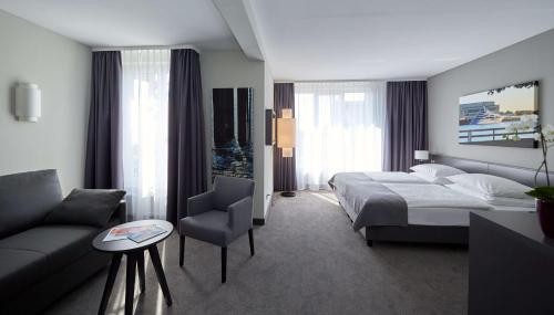 une chambre d'hôtel avec un lit et un canapé dans l'établissement Atlantic Hotel Vegesack, à Vegesack