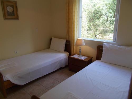 two beds in a room with a window at Villa Aphrodite in Rizá