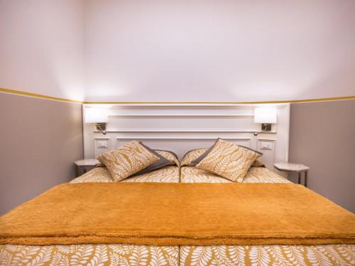 a bed with an orange blanket and two pillows at da Benedetta in Monterosso al Mare