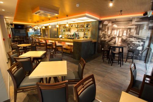 a restaurant with tables and chairs and a bar at Hotel Novo Cándido in Ourense
