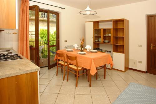 a kitchen with a table and chairs in a room at Residence Ruculì - Ruculì Hospitality in Tignale