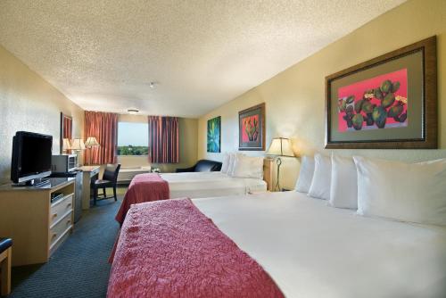 a hotel room with a large bed and a television at Oxford Suites Lancaster in Lancaster