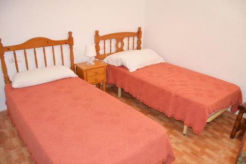 デニアにあるCabañas 3 LOCDENIAのベッド2台が隣同士に設置された部屋です。