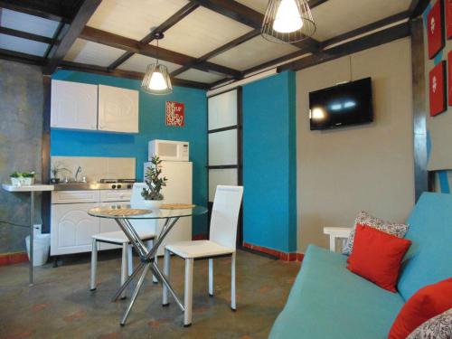 a living room with a table and a kitchen at Satya Suites & Portal San Angel Flats in Mexico City