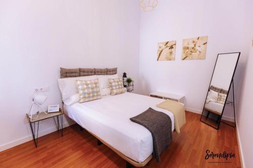 1 dormitorio con 1 cama blanca grande y espejo en Serendipia en Cáceres