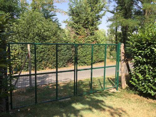 a green gate in front of a fence at B&B Nido Sui Laghi in San Donnino della Nizzola