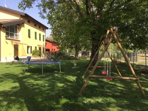 a swing set in a yard with a trampoline at B&B Nido Sui Laghi in San Donnino della Nizzola