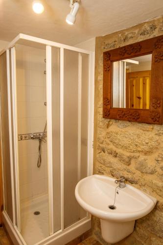 a bathroom with a sink and a shower and a mirror at Pensión Rustica Alemana in Muxia