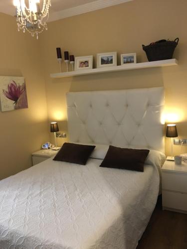 a bedroom with a white bed with two pillows at New Apartment & Parking Alcazaba in Málaga