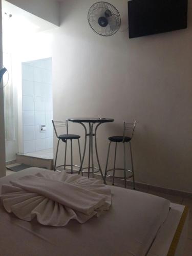 a room with two tables and two bar stools at Motel Delamar (Adult Only) in Belo Horizonte