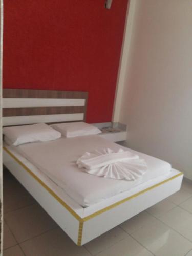 uma cama com lençóis brancos e almofadas brancas em Motel Delamar (Adult Only) em Belo Horizonte
