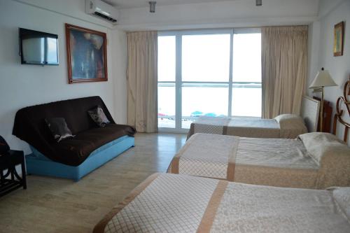 een woonkamer met 2 bedden en een bank bij Salvia Condominio in Cancun