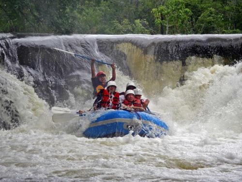 a group of people on a raft in a waterfall at Campamento Rio Lacanja in Lacanjá