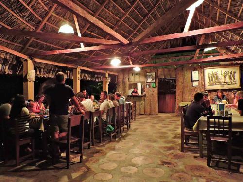 a group of people sitting at tables in a restaurant at Campamento Rio Lacanja in Lacanjá