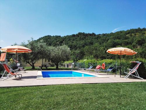 a swimming pool with two chairs and umbrellas at Brigida in Verucchio