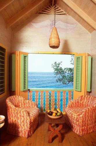 a room with two chairs and a large window at The Caves in Negril