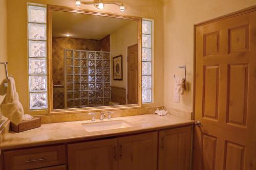 baño con lavabo y espejo grande en Dunas 102, en Cabo San Lucas