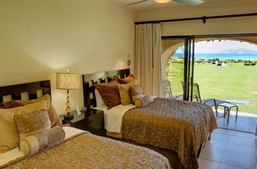 1 dormitorio con 2 camas y vistas al océano en Dunas 102, en Cabo San Lucas
