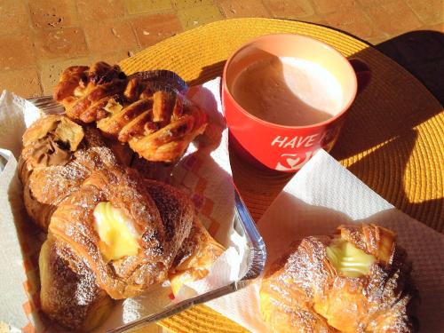 bandeja de bollería en una mesa con una taza de café en B&B Villa Jasiga, en Fregene