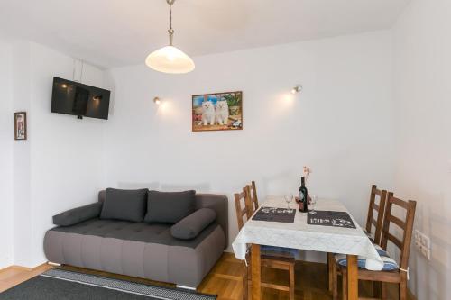uma sala de estar com um sofá e uma mesa em Apartments Oliva em Cavtat