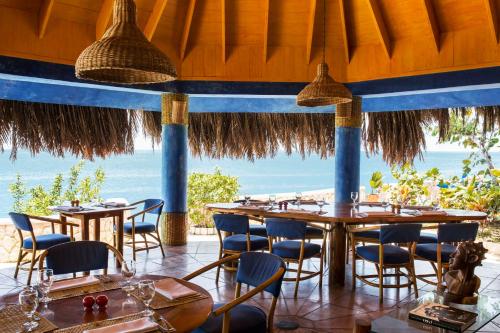 a restaurant with tables and chairs and a view of the ocean at The Caves in Negril