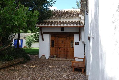 a wooden door to a house with a bench in front at Casa Rural La Alameda in Madridejos
