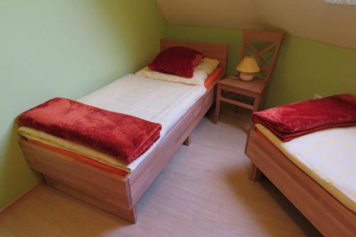 two twin beds in a small room with a lamp at Stollenklause in Hormersdorf
