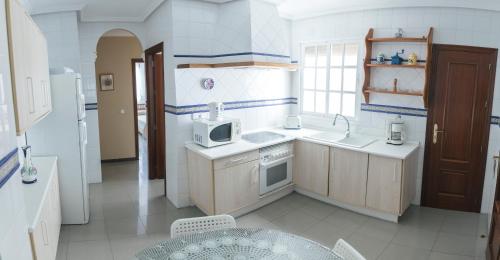 a kitchen with a sink and a microwave at Casa Clara, Caminito de Rey in Valle de Abdalagís