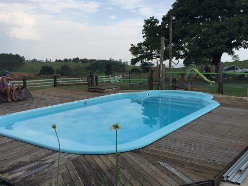 una gran piscina azul en una terraza de madera en Chales da Serra en São Pedro