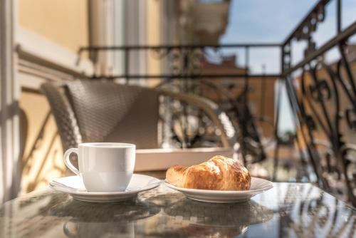 a table with a cup of coffee and a croissant at Luxury Apartments Centre of Opatija in Opatija