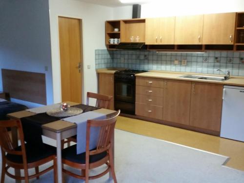 a kitchen with a table and chairs and a kitchen with a sink at Apartmány Gryf Harrachov in Harrachov